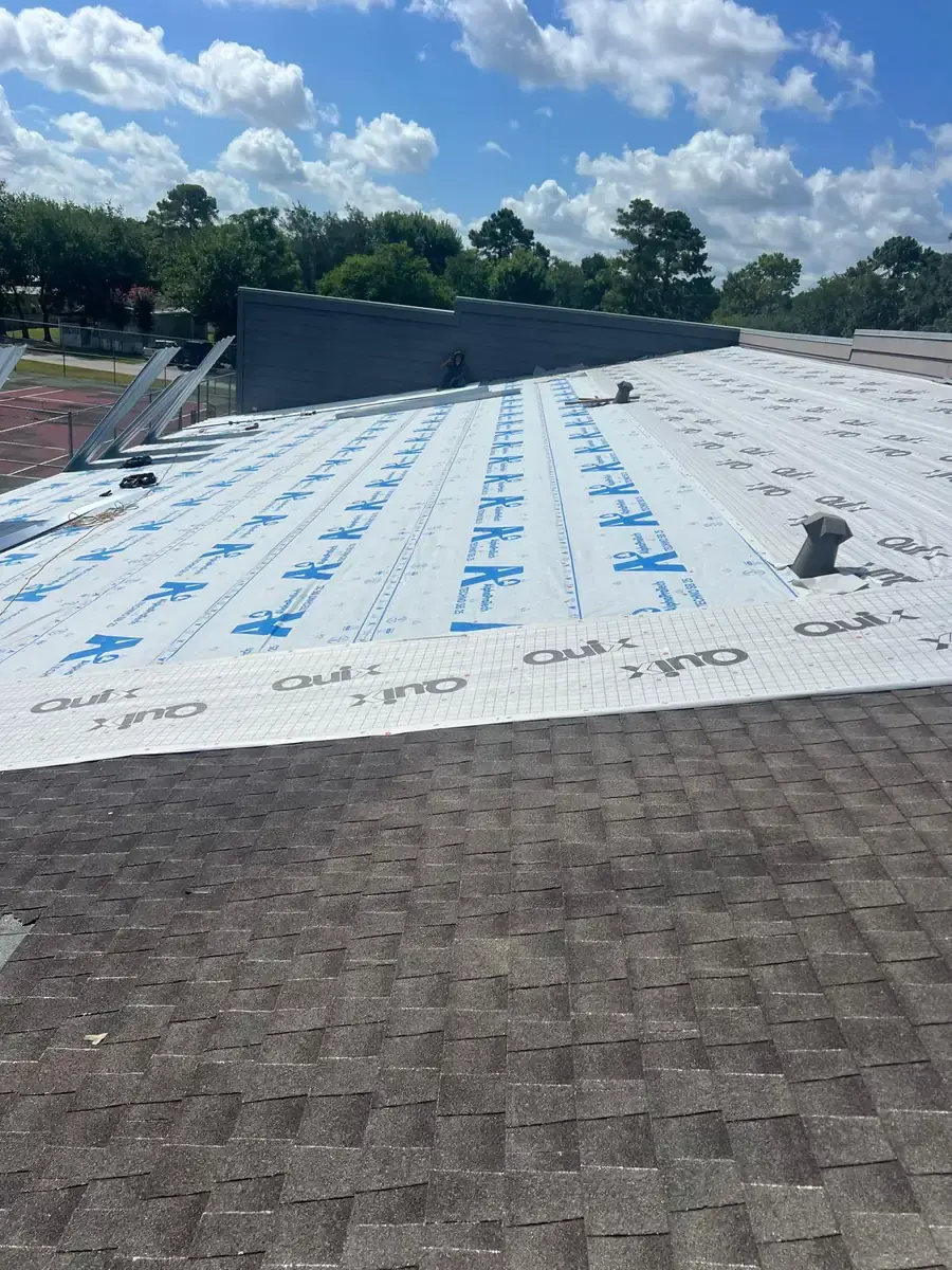 Synthetic roof underlayment around vents beside an existing shingle section