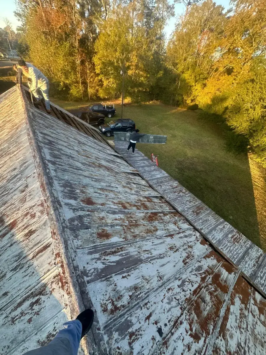 Weathered metal roofing with worn paint along a pitched roof