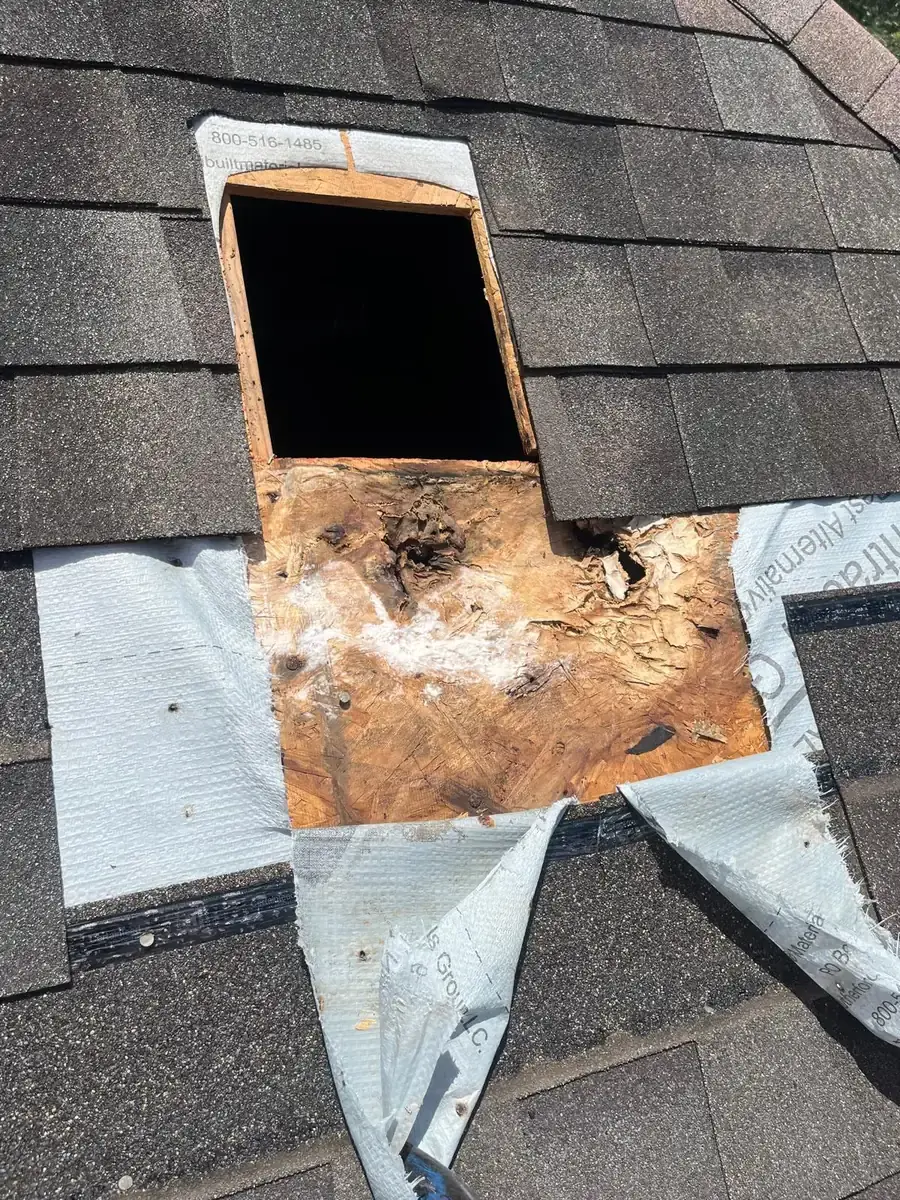 Damaged wood decking below a square roof vent opening
