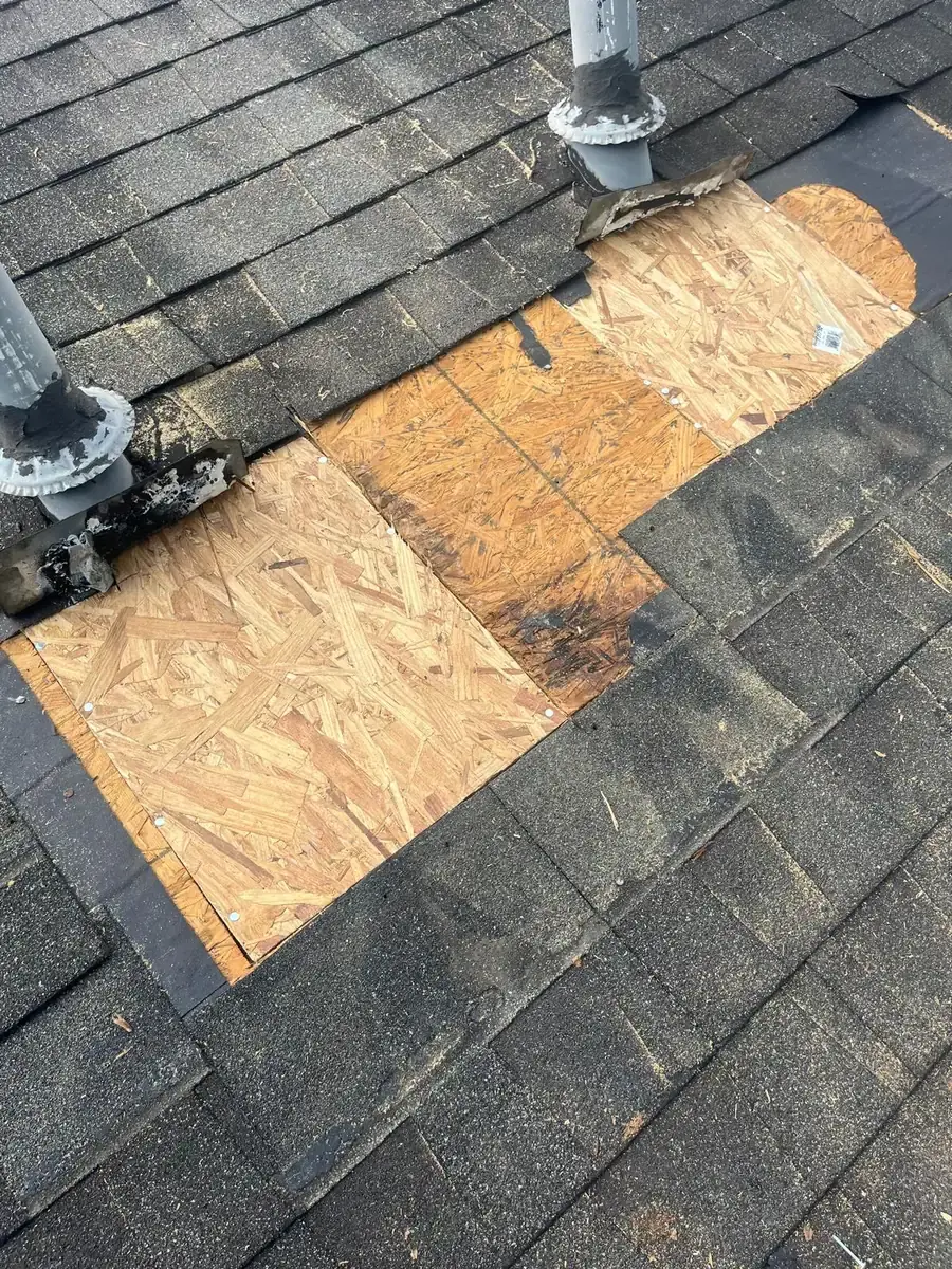 Replacement wood decking fitted around two roof pipe penetrations